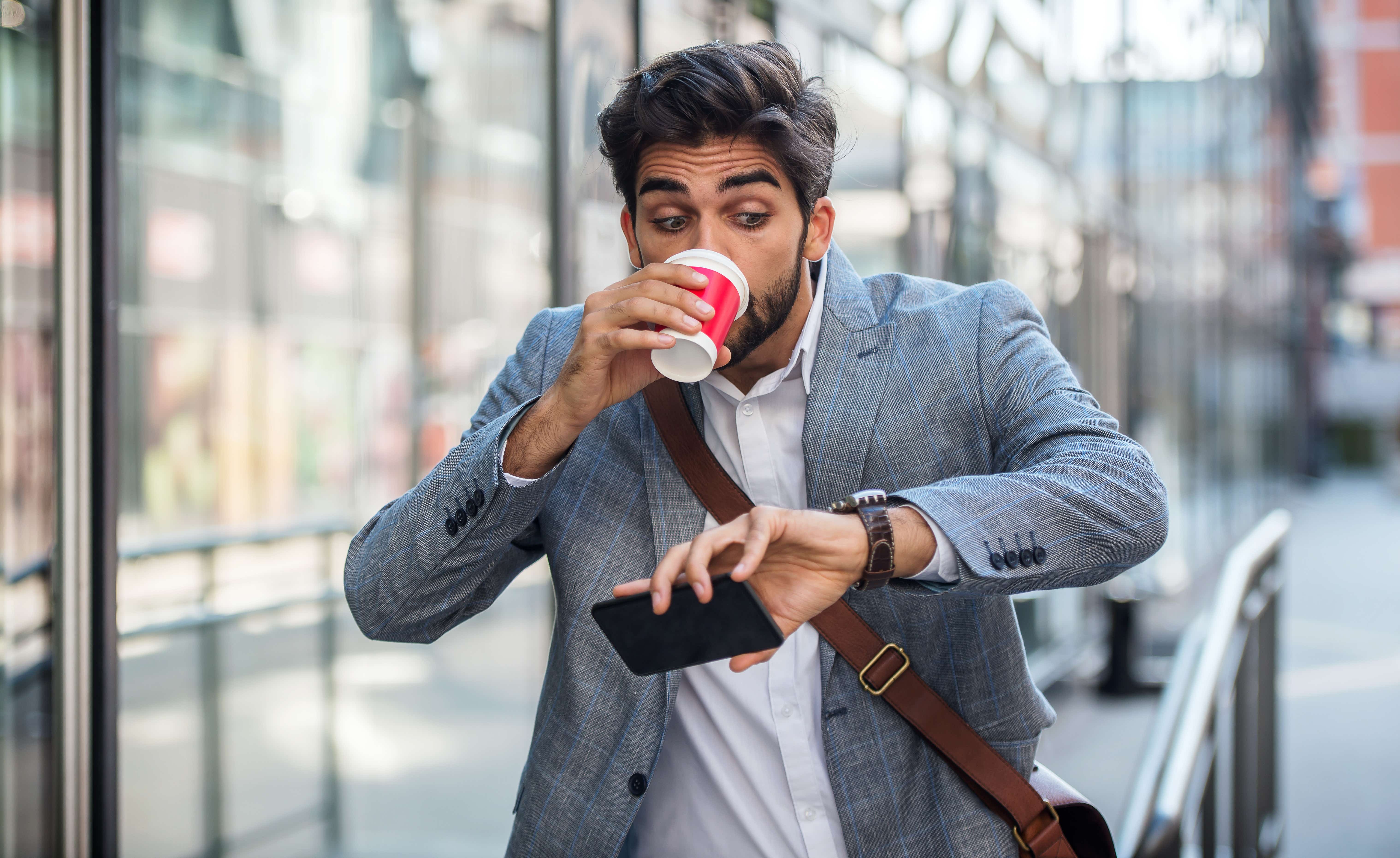 Worried businessman looking at his watch on the way to office. 