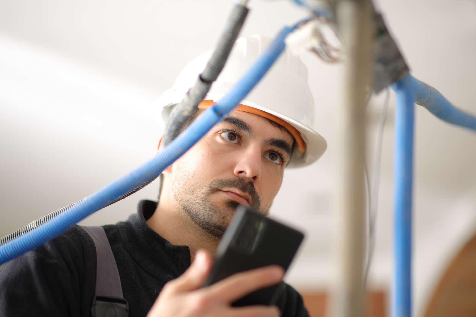 Electrician checks wiring on a construction site.