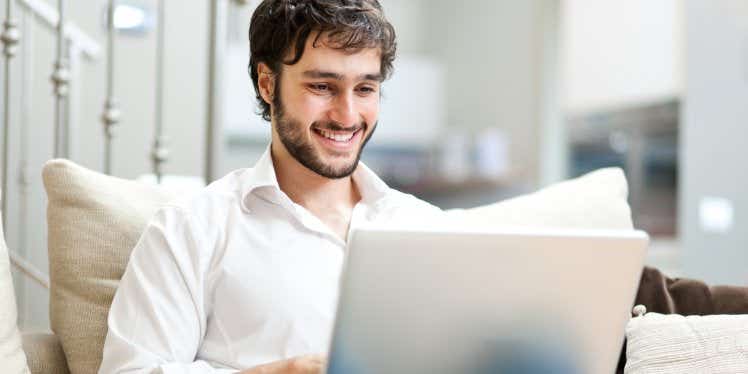 happy-man-on-laptop-at-home-alone