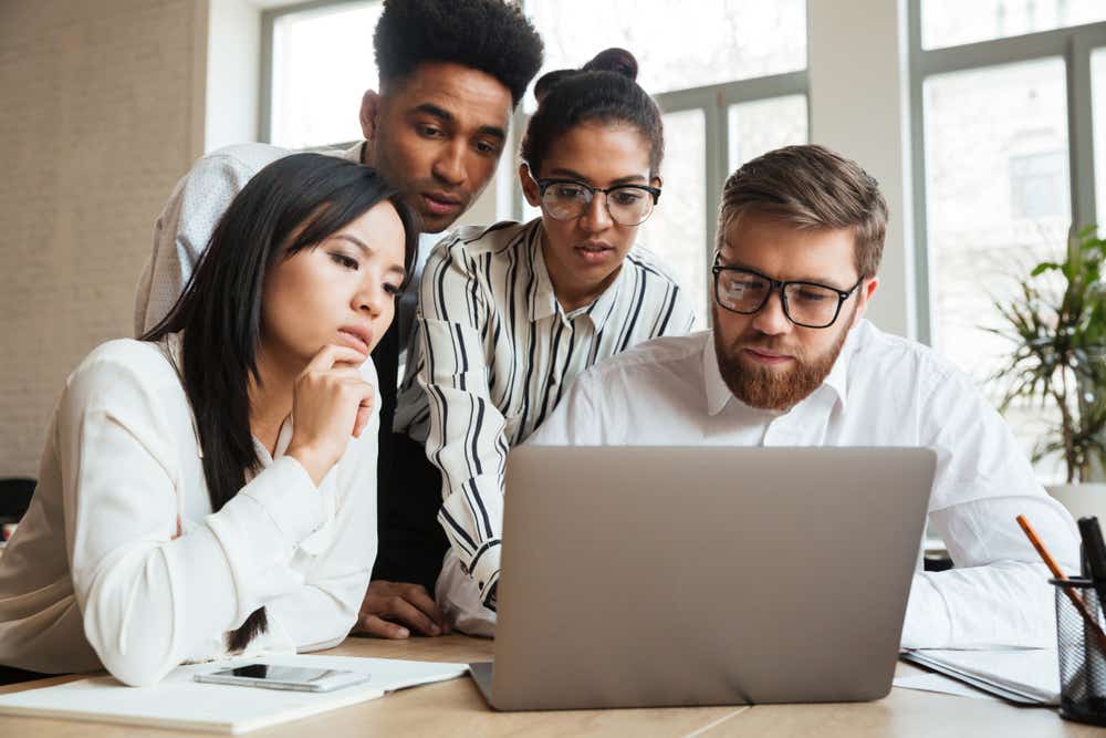 A group of people looking concerned at a laptop