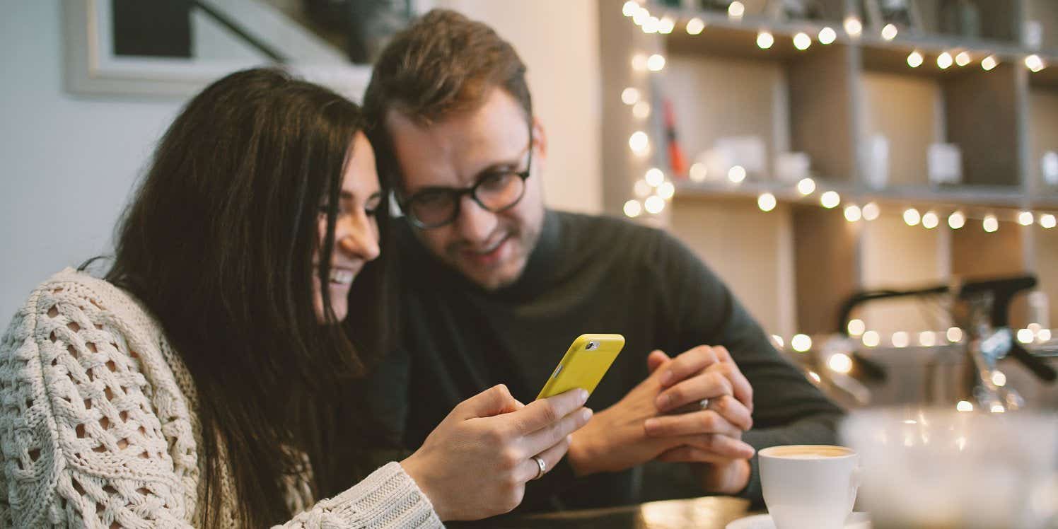 Couple in coffee shop using mobile phone
