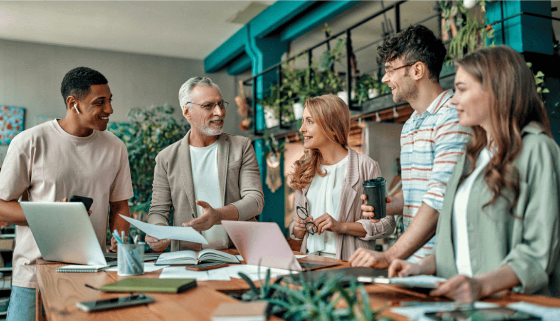 A-group-of-employees-gathered-in-a-bright,-modern-office-environment,-engaged-in-conversation