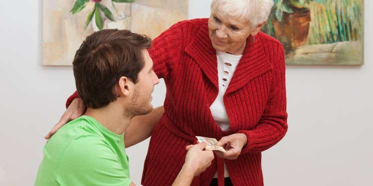 old woman giving money to man