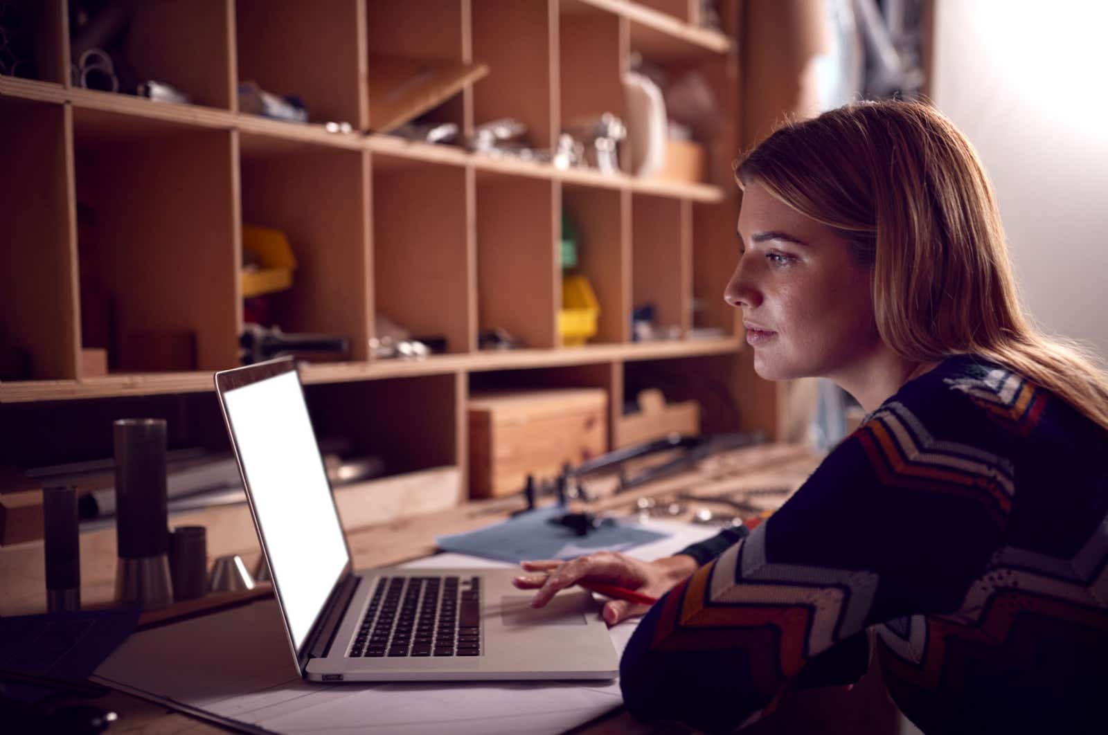Craftswoman working on her laptop in the evening