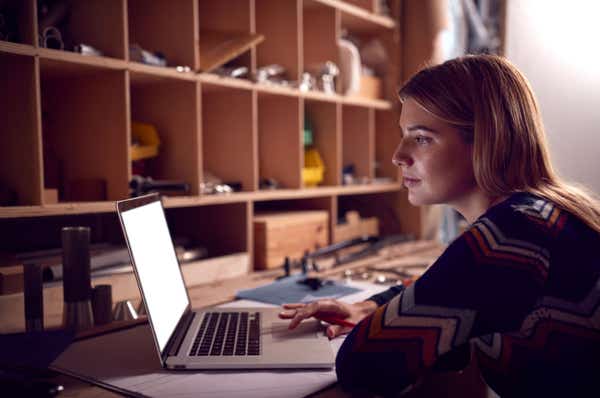 Craftswoman working on her laptop in the evening