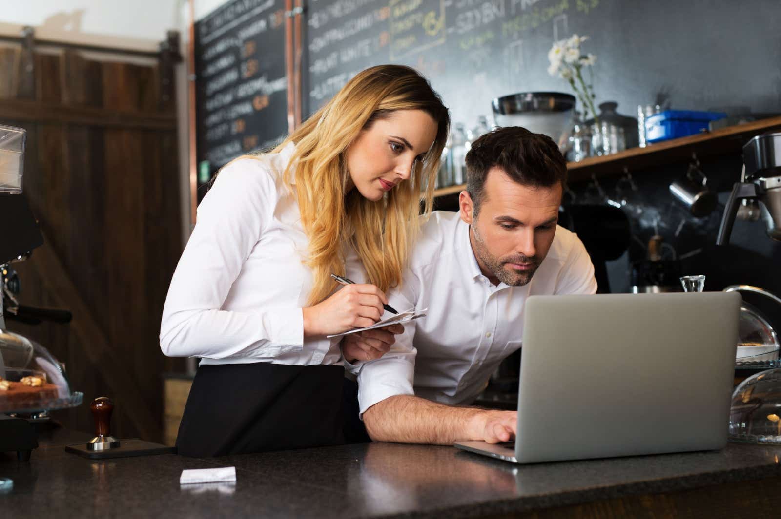 Business partners in a cafe, work together on a screen
