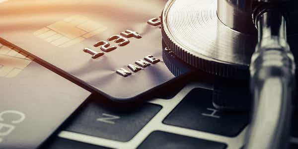 A picture of two credit cards on top of a laptop keyboard