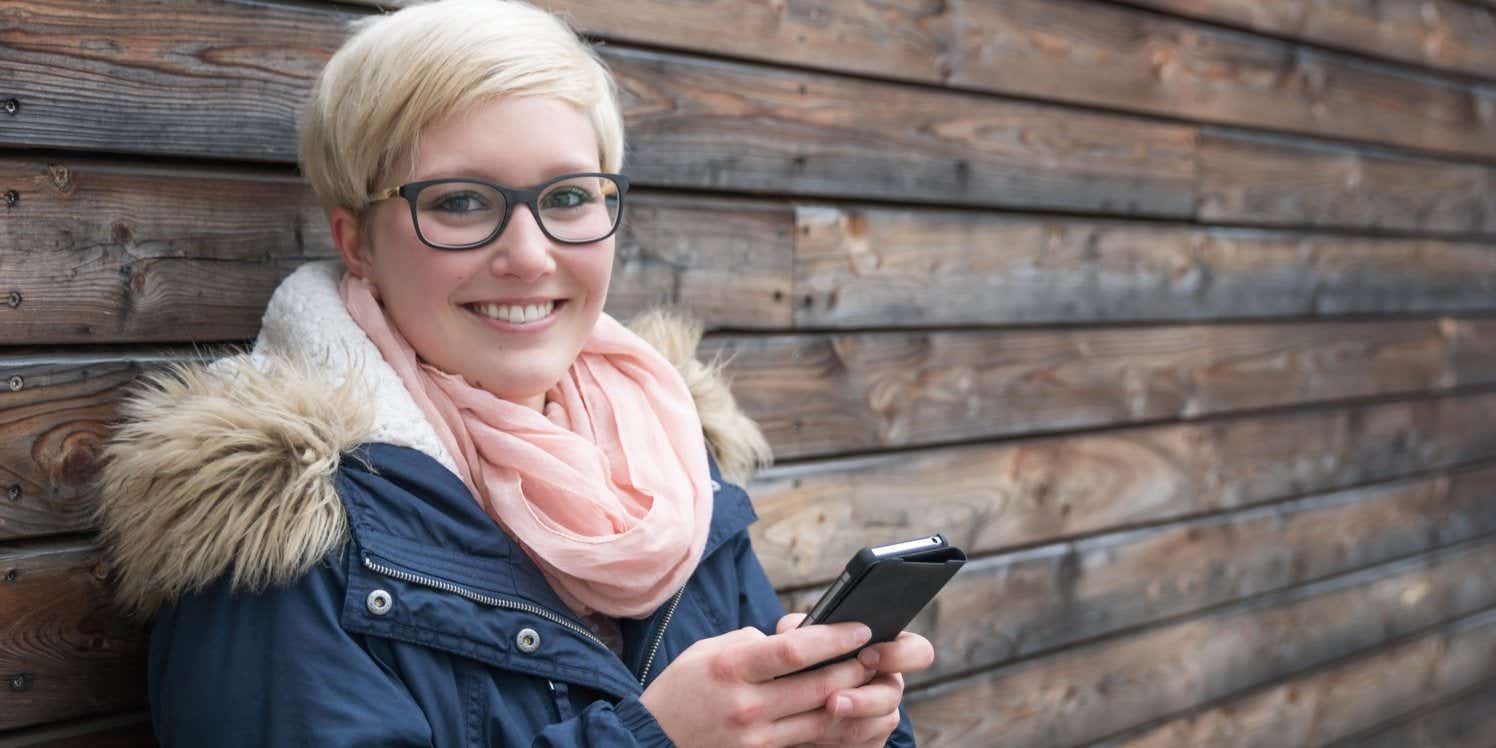 Smiling woman holding smartphone