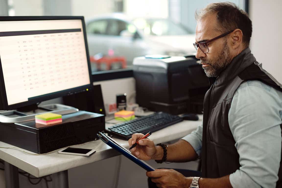 Owner of a car repair company at his desk doing paperwork. 