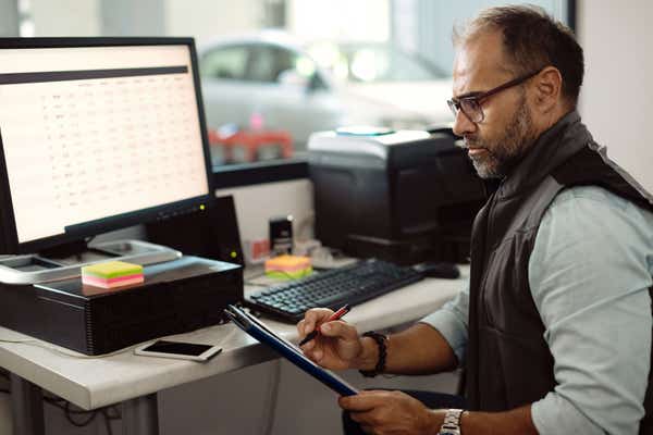 Owner of a car repair company at his desk doing paperwork. 