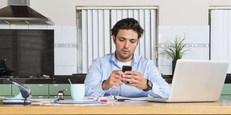 man-in-kitchen-with-laptop-paperwork-and-calculato