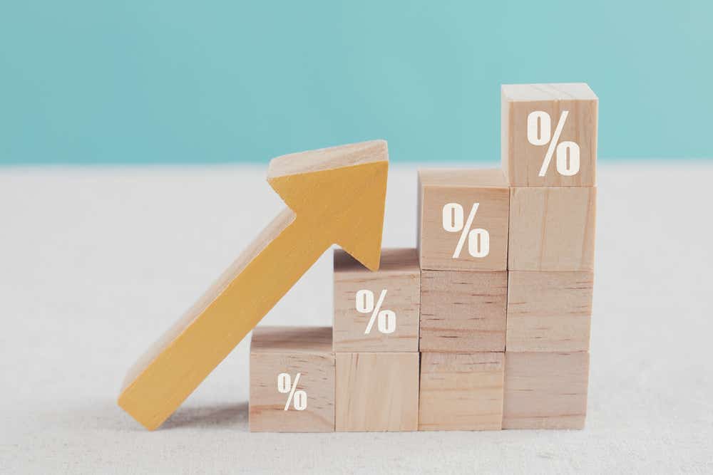 Wooden blocks with percentage icon and an arrow going upwards.